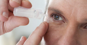 A man using eye drops